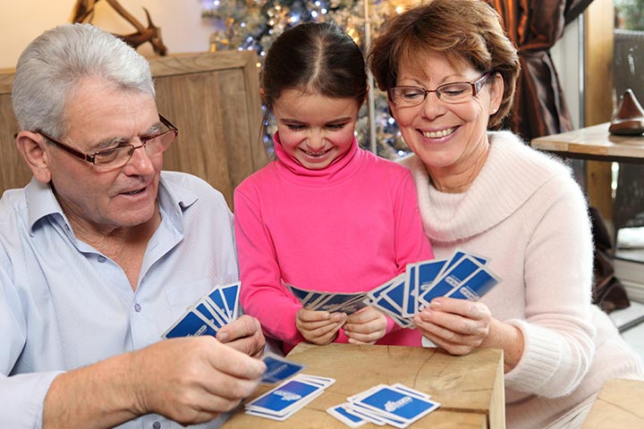 Granparents playing cards with grandchild